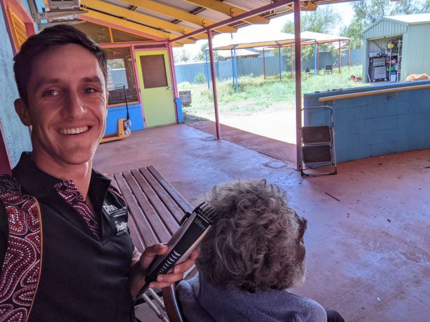 young man cutting Aboriginal man's hair with clippers