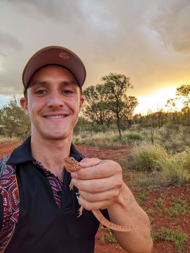 Young man holding lizard