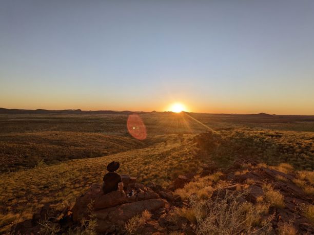 man in black hat looking at sunset