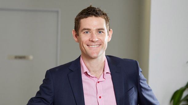 main in suit and pink open-necked business shirt