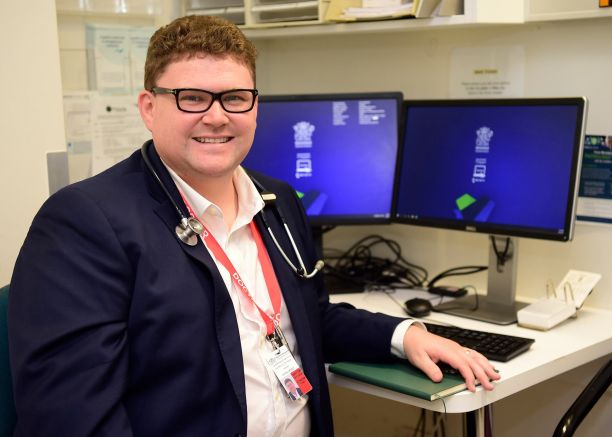 man in glasses in front of computer
