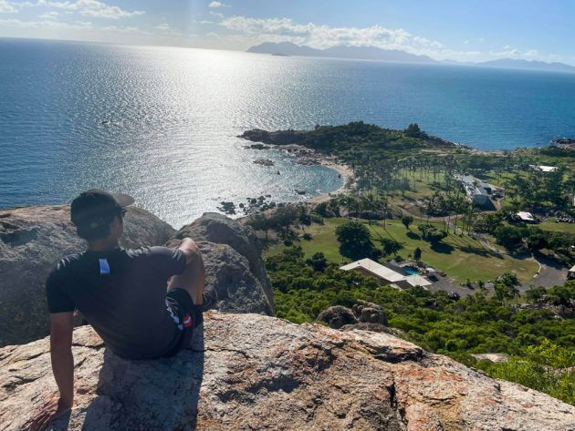 Man on rock high above coastline