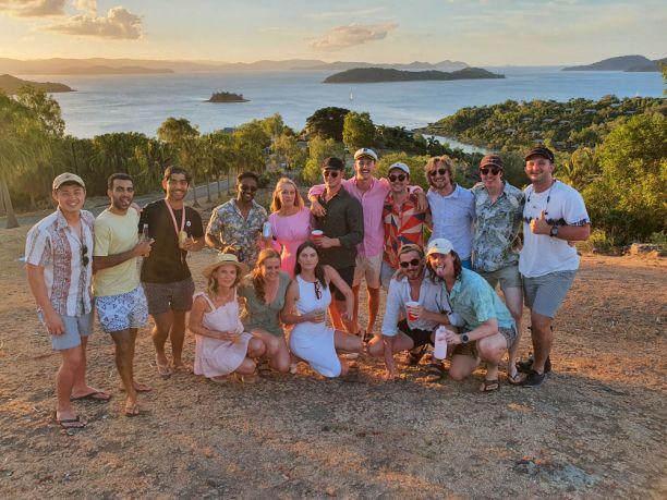 Group of young people at scenic island looking with islands in background at sunset