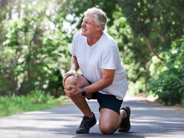 A man clutches his sore knee. 