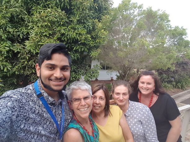 Group taking selfie of one man and four women