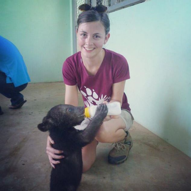 Sheridan bottle feeding a baby bear while working with Animals Asian 