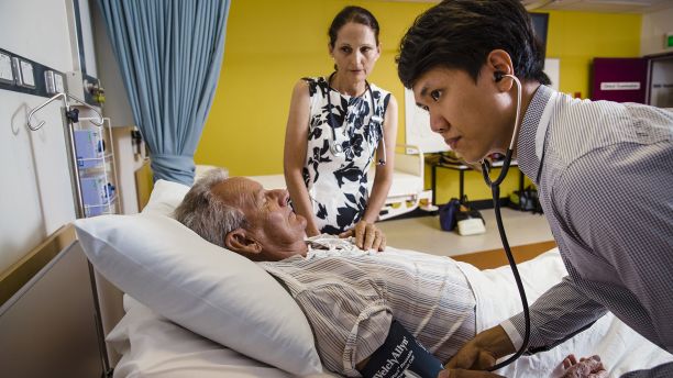 Nurse practitioner supervises a medical trainee with patient