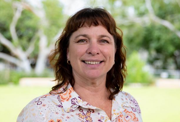 Close up image of Dr Rachel Hay, with greenery in the background. 