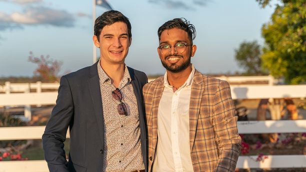 three men in sports coats at outdoor event at night