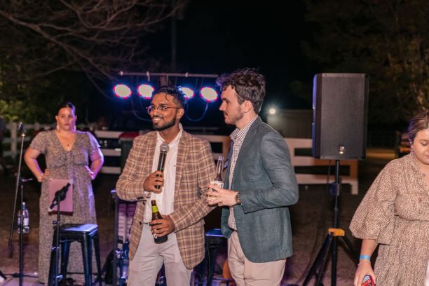 two men at microphone at formal outdoors event