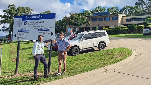 two men at Sarina Hospital sign on hospital grounds